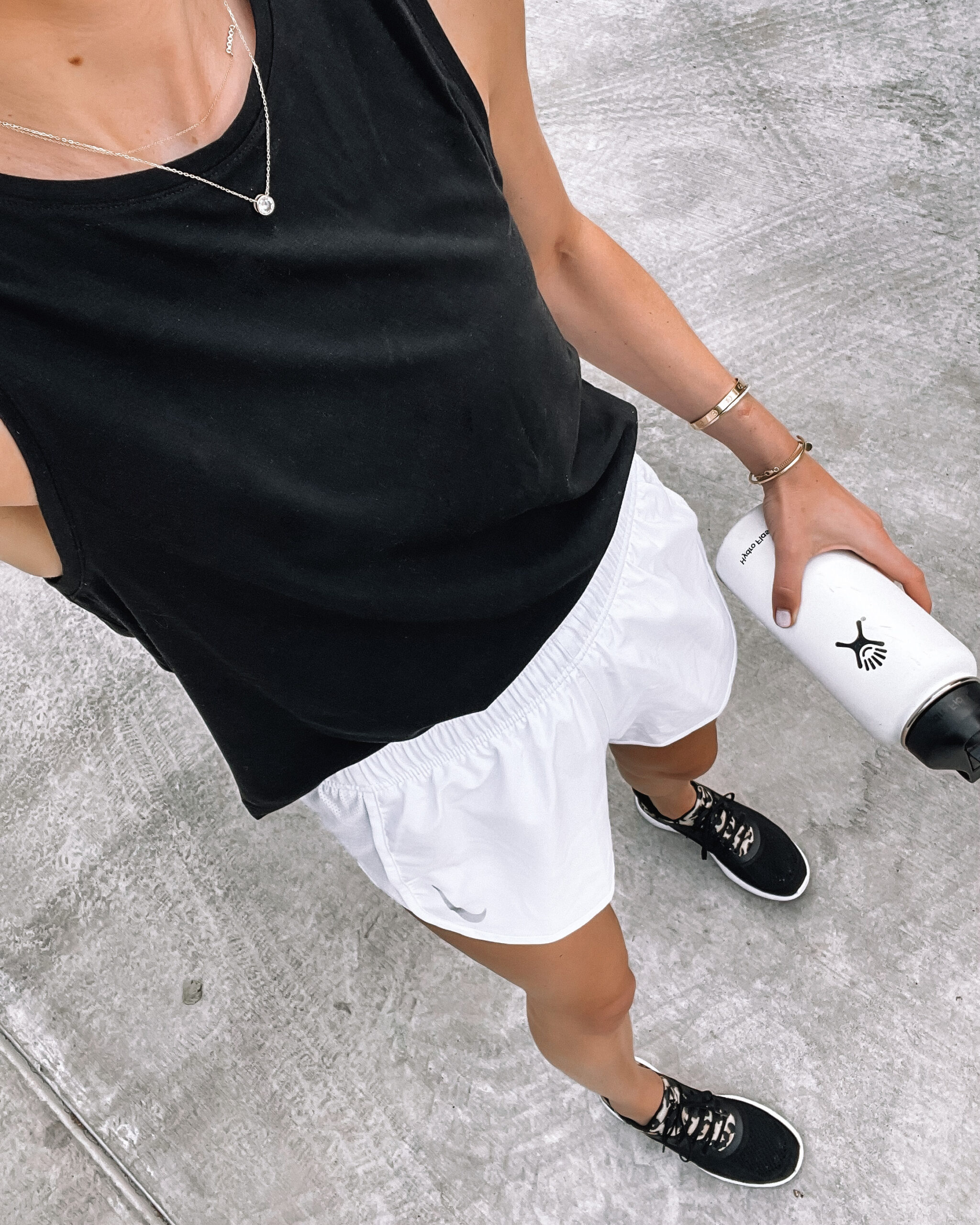 Fashion Jackson Wearing Black Muscle Workout Tank White Nike Running Shorts With Liner APL Black Leopard Sneakers White Hydroflask Womens Workout Outfit