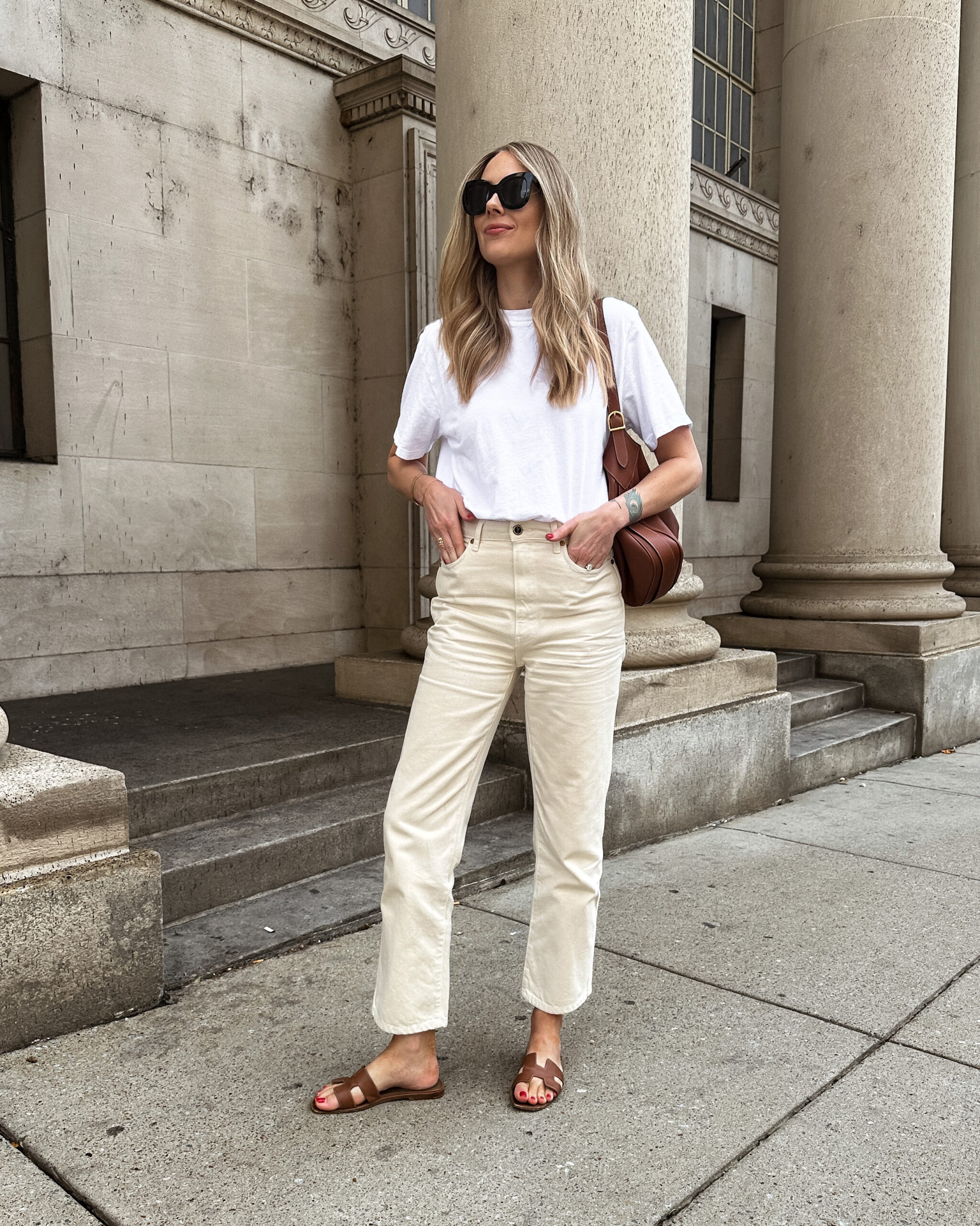 Fashion Jackson Wearing Askk NY Boy Tee White, Khaite Abigail Jeans Ivory, Hermes Oran Gold Sandals, Celine Romy Large Handbag, Casual white jeans outfit