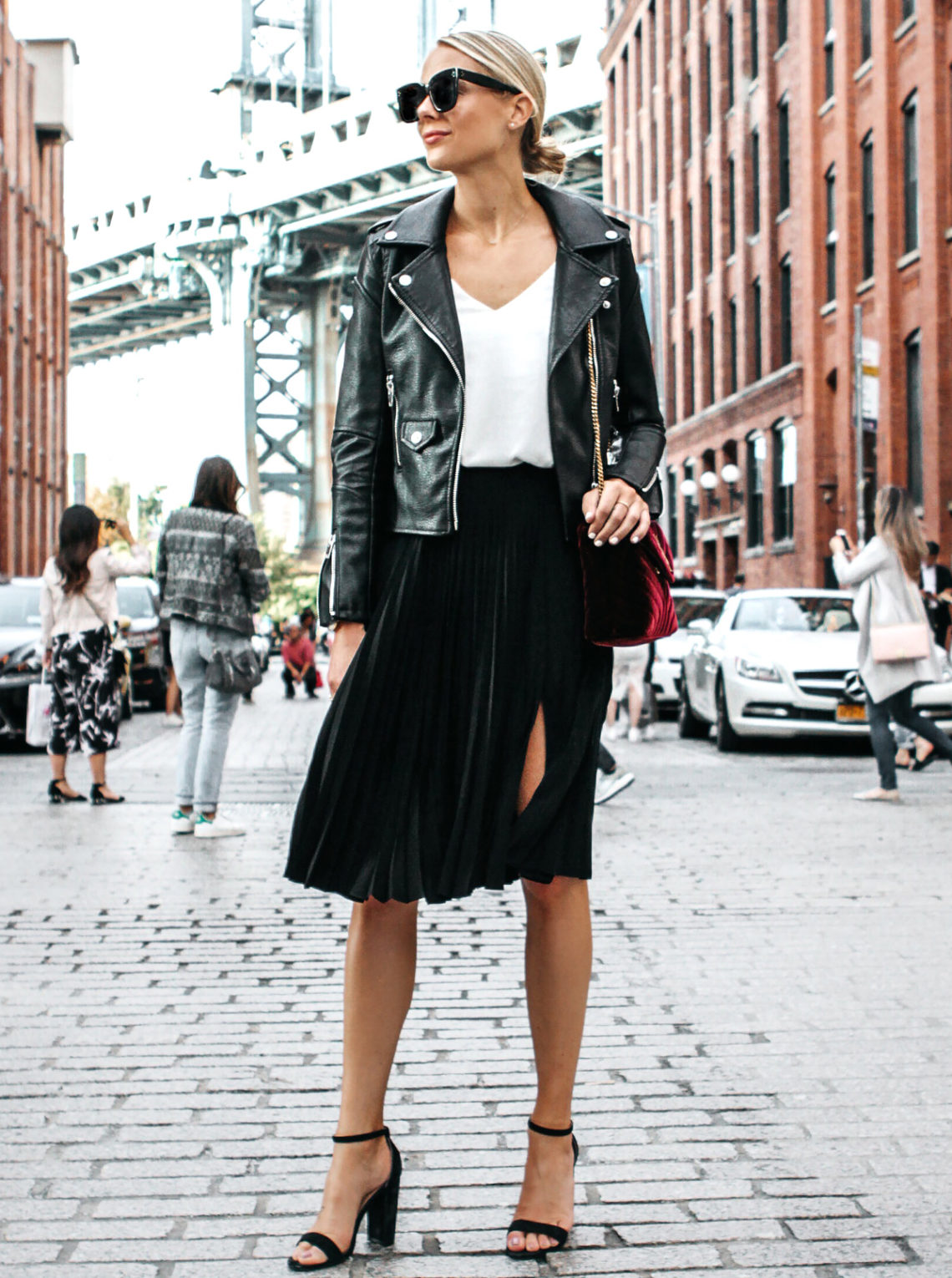 Blonde Woman Wearing Black Leather Jacket Black Pleated Midi Skirt Saint Laurent Burgundy Velvet Bag Black Ankle Strap Heeled Sandals Fashion Jackson Dallas Blogger Fashion Blogger Street Style NYFW Dumbo Bridge