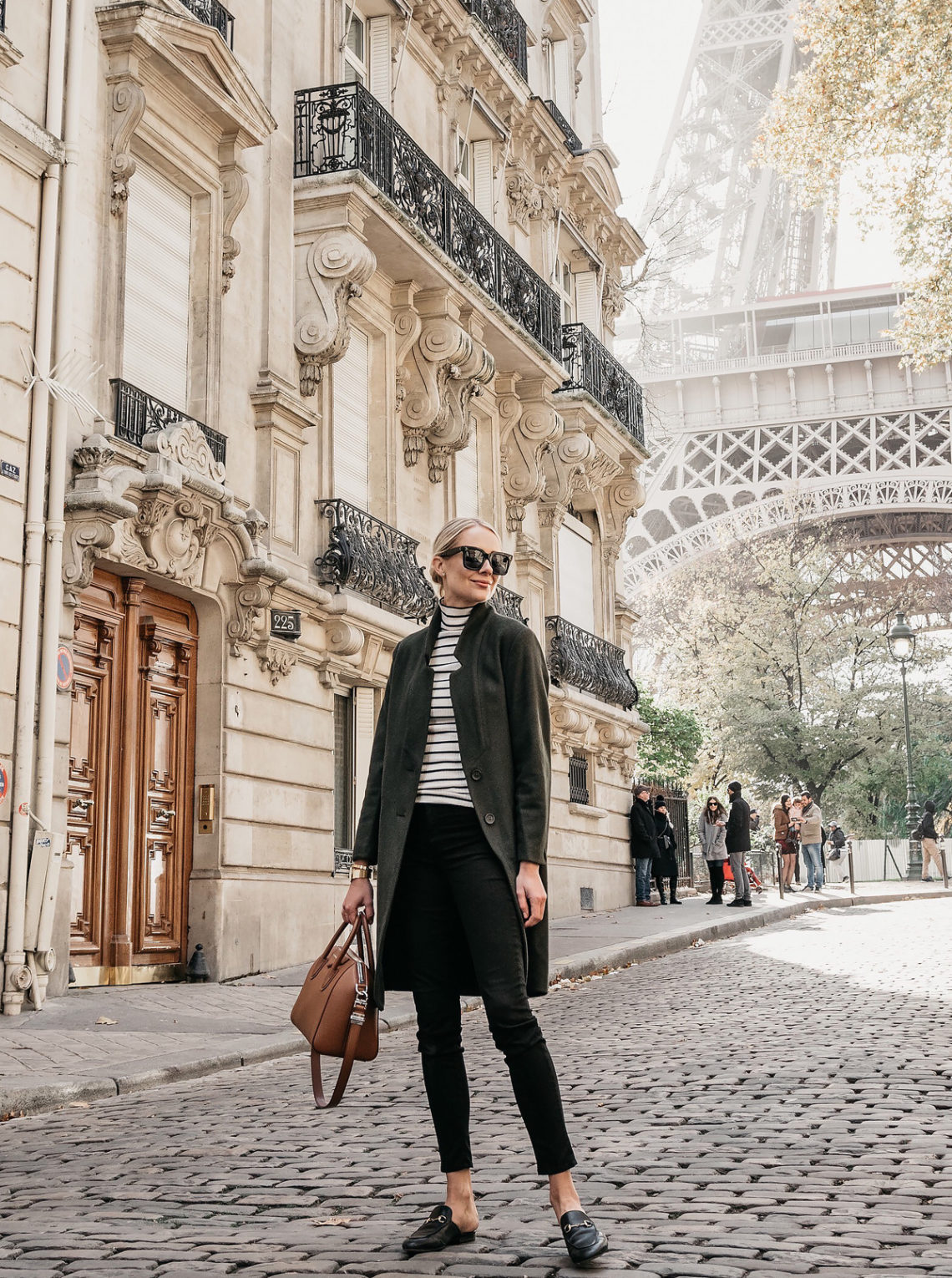 Eiffel Tower Paris France Blonde Woman Wearing Green Wool Coat Black White Stripe Turtleneck Black Skinny Jeans Givency Antigona Cognac Satchel Gucci Mules Fashion Jackson Dallas Blogger Fashion Blogger Street Style